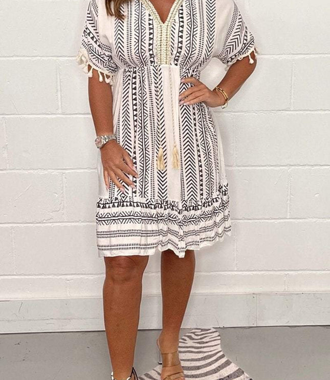 Black boho geometric V neck mini dress with tassel details and short sleeves