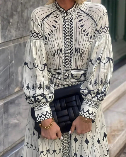 Front view of long sleeve printed midi dress with button placket, belted waist, and patterned cuffs