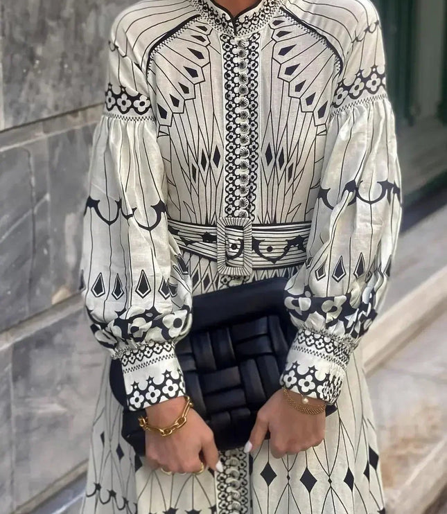 Front view of long sleeve printed midi dress with button placket, belted waist, and patterned cuffs