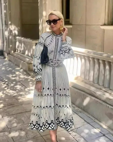 Full length A line midi dress with black and white print, long sleeves, and flowing skirt