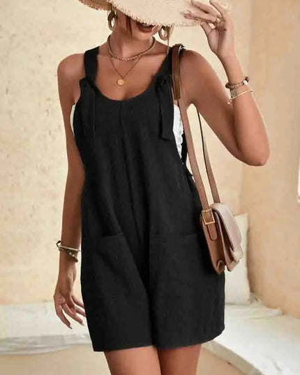 Black linen romper with knotted shoulder straps and side pockets