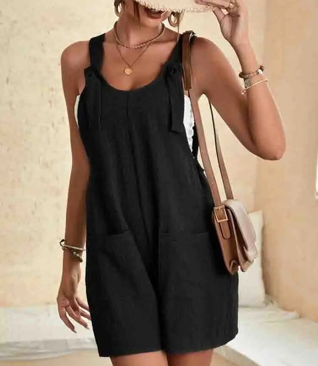 Black linen romper with knotted shoulder straps and side pockets