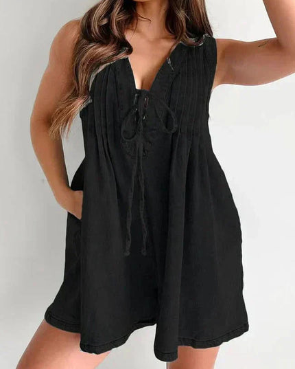 Black women's denim romper with sleeveless V-neck, tie front, and loose mini short silhouette