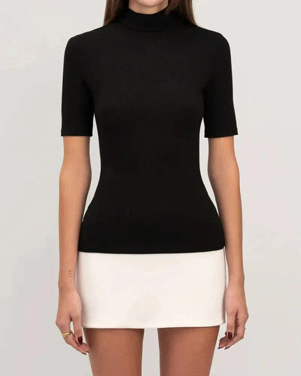 Mid-length detail of fitted mock neck mini dress showing smooth black top and white skirt