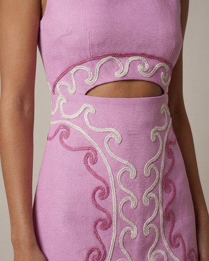 Close-up of pink embroidered cocktail dress showing waist cutout and textured stitching