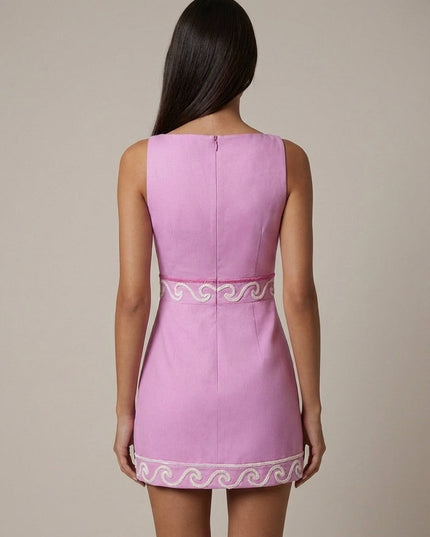 Back view of pink dress showing center zip closure and embroidered waist band