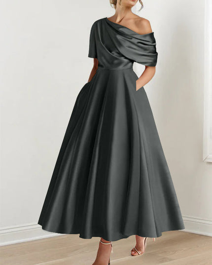 Charcoal gray one-shoulder maxi dress with draped sleeve and flowing skirt