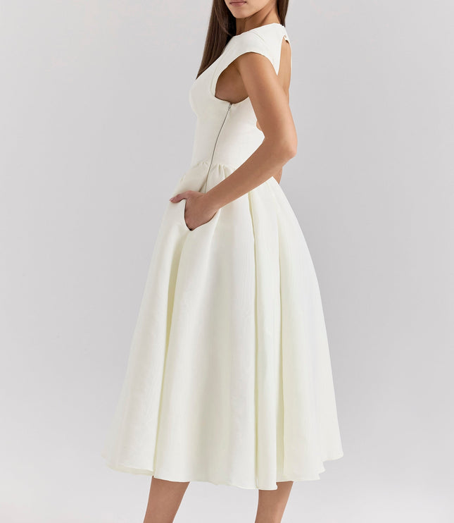 Side view of ivory cocktail dress with open back and fitted waist
