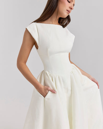 Close-up side view of ivory cocktail dress showing open back and waist seams