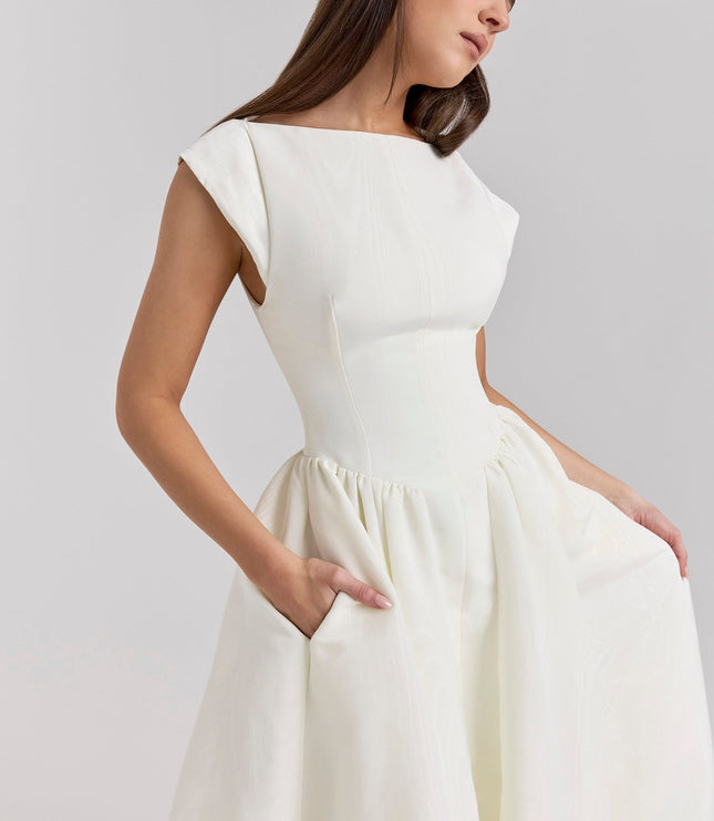 Close-up side view of ivory cocktail dress showing open back and waist seams