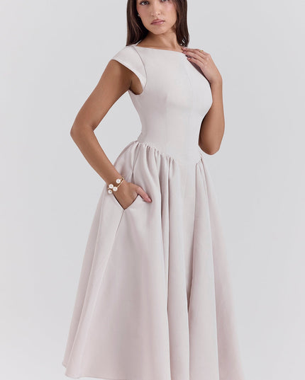 Side view of a blush cocktail midi dress with cap sleeves and gathered skirt