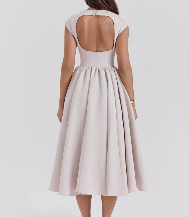Back view of a blush open back midi dress with cap sleeves and flared skirt
