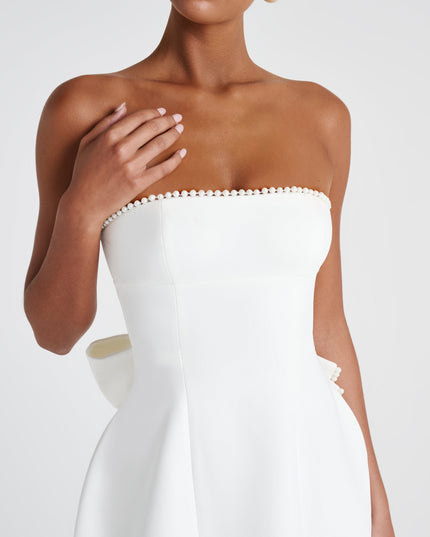 Close-up of white strapless dress showing pearl-beaded neckline detail