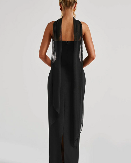Back view of black strapless maxi dress with sheer overlay and slit detail