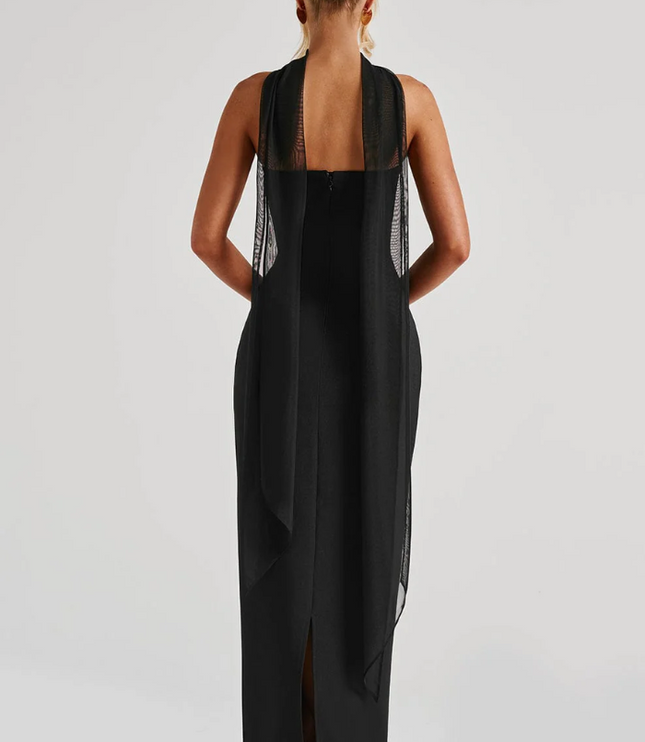 Back view of black strapless maxi dress with sheer overlay and slit detail