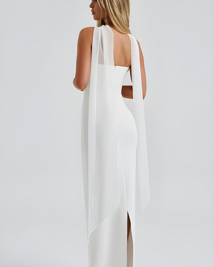 Back view of white strapless maxi dress with flowing sheer overlay and slit