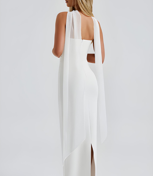 Back view of white strapless maxi dress with flowing sheer overlay and slit