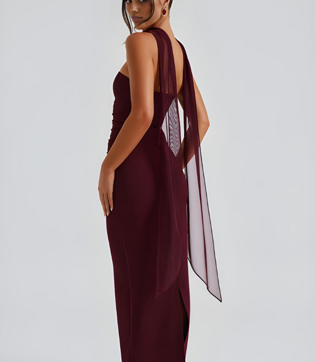 Back view of burgundy strapless maxi dress with sheer overlay and open back detail