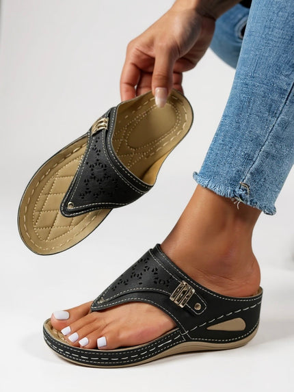 Black thong sandal with cushioned footbed and perforated strap detail, shown on foot