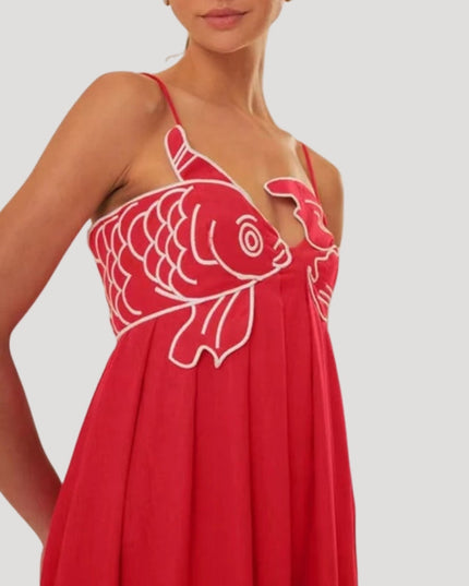 Close-up of the red cami maxi sundress showing white embroidered fish and crab detail on the bust, spaghetti straps.