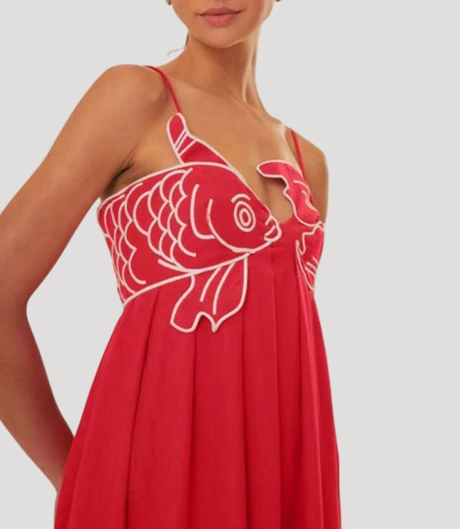 Close-up of the red cami maxi sundress showing white embroidered fish and crab detail on the bust, spaghetti straps.