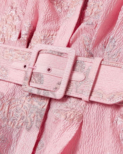 Close-up of pink belted maxi dress showing textured floral fabric and buckle detail