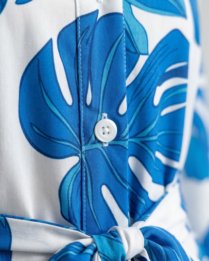 Close-up of blue floral shirt dress fabric with button placket and tie waist detail
