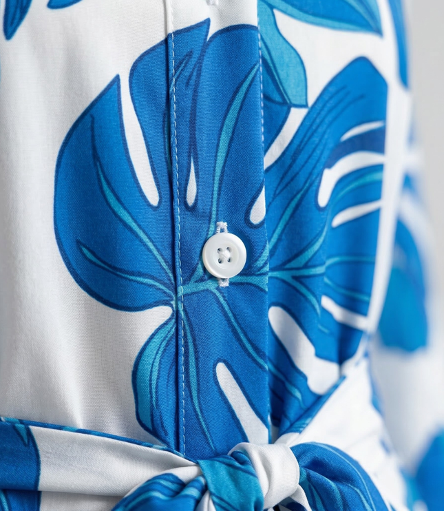 Close-up of blue floral shirt dress fabric with button placket and tie waist detail
