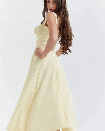Side view of pale yellow midi dress with fitted bodice and flowing skirt
