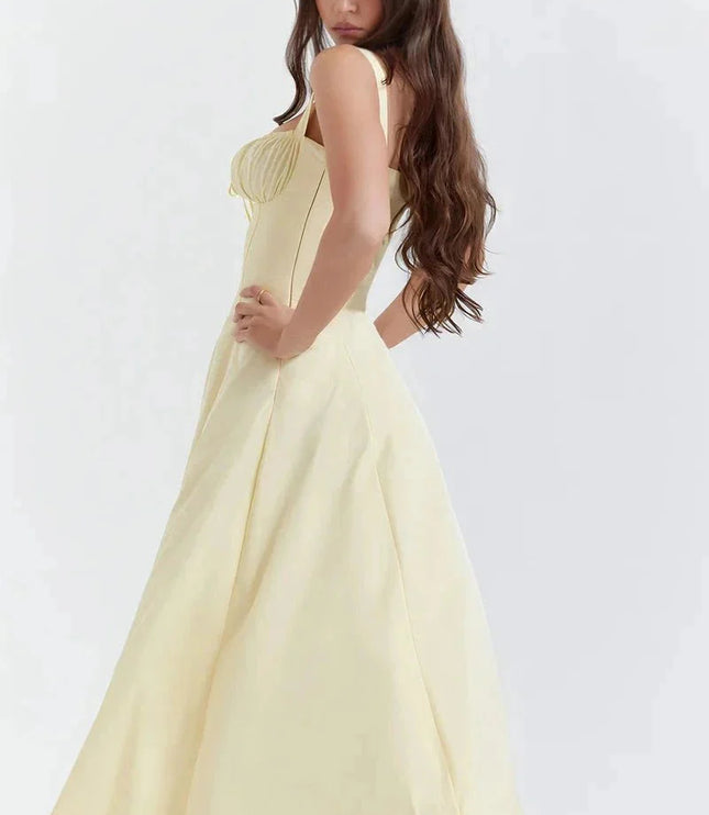 Side view of pale yellow midi dress with fitted bodice and flowing skirt