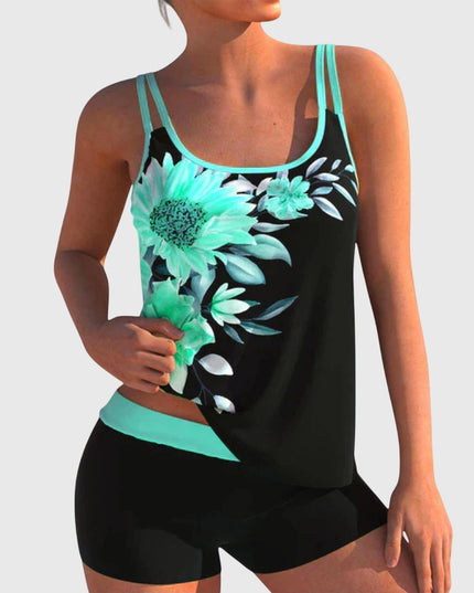Black tankini top featuring turquoise daisy and floral print with cyan trim and black shorts