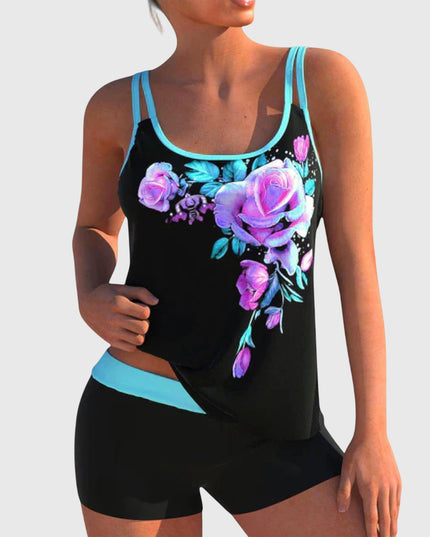 Black tankini top with purple and magenta floral print and turquoise trim paired with black shorts