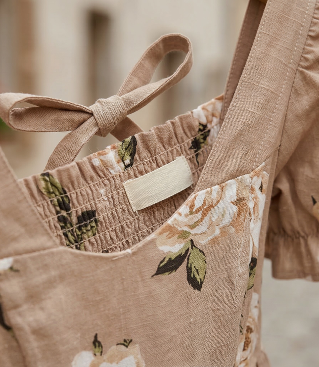 Close-up of floral square neck midi dress showing smocked bodice, back tie, and puff sleeve