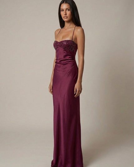 Three-quarter view of burgundy beaded halter gown with satin finish