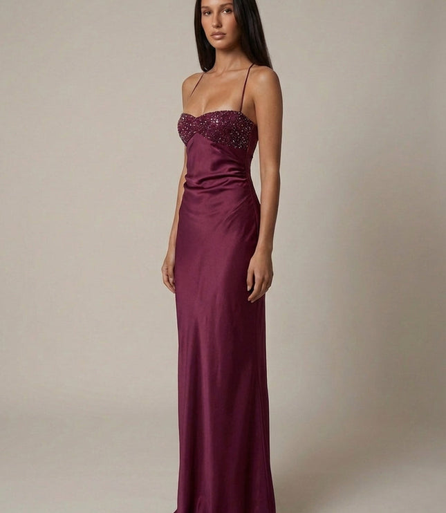 Three-quarter view of burgundy beaded halter gown with satin finish
