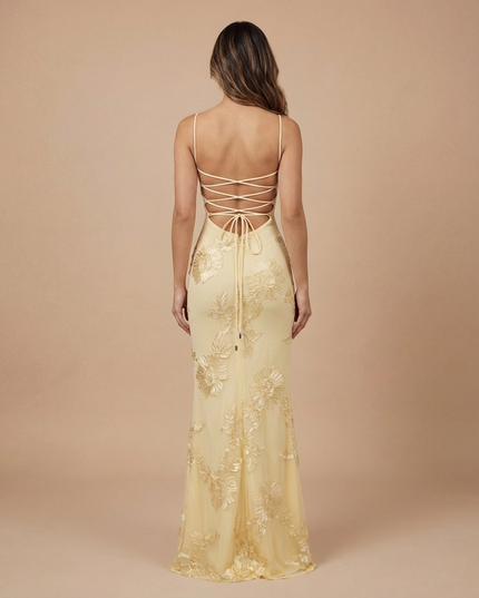 Back view of a pale yellow floral V neck maxi dress with crisscross lace-up back