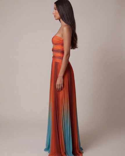 Side view of strapless ombre maxi dress with ruched bodice and flowing pleated skirt