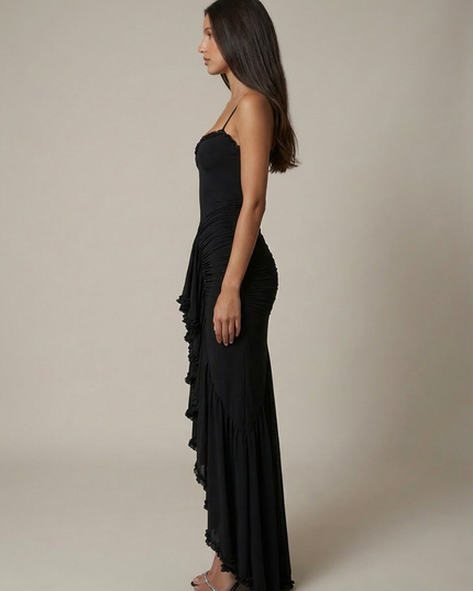 Side view of black cocktail maxi dress with fit, spaghetti straps, and floor-length ruffles