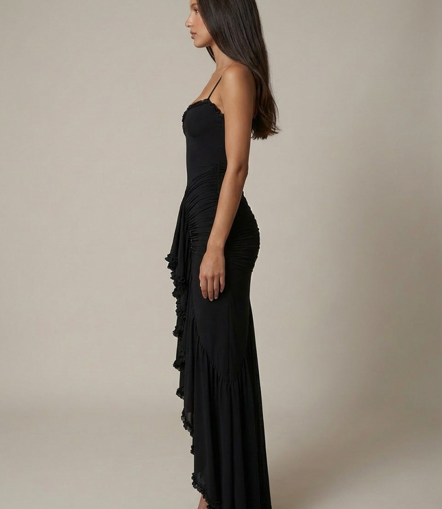 Side view of black cocktail maxi dress with fit, spaghetti straps, and floor-length ruffles