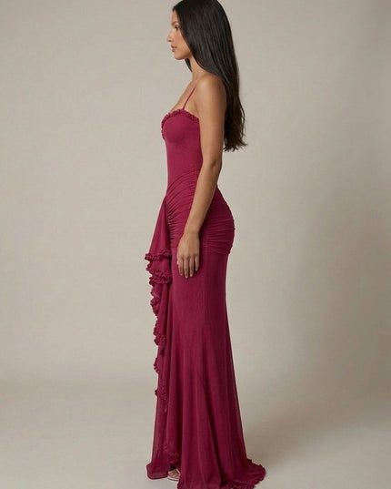 Side view of magenta cocktail maxi dress showing fit, spaghetti straps, and ruffled front panel
