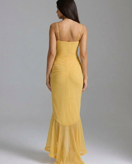 Back view of yellow maxi dress with fitted silhouette, sheer hem, and spaghetti straps