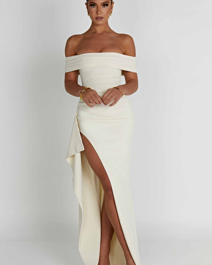 Cream off shoulder maxi dress with high slit and flowing skirt, angled front view