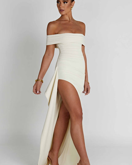 Side view of cream formal maxi dress with off shoulder neckline and draped back panel