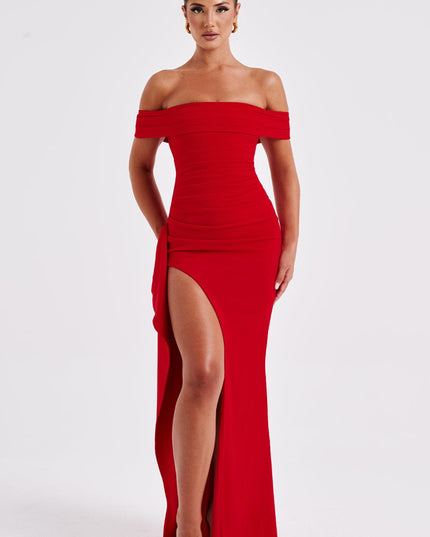 Angled front view of red off shoulder maxi dress with fitted waist and flowing skirt