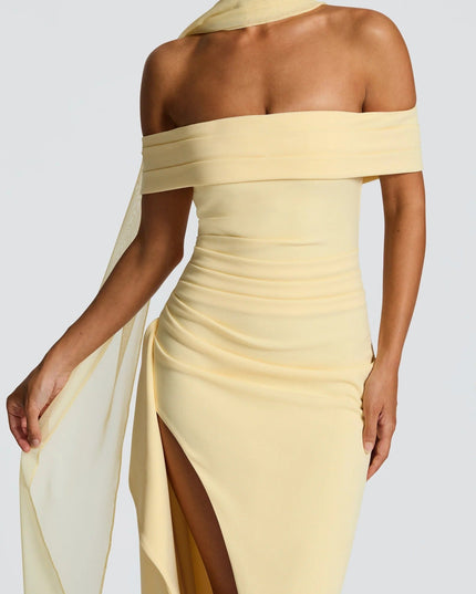 Close up of pale yellow off shoulder maxi dress showing draped neckline and thigh slit detail