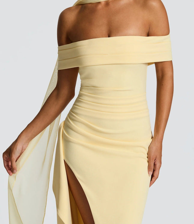 Close up of pale yellow off shoulder maxi dress showing draped neckline and thigh slit detail