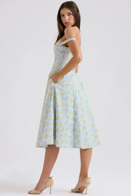 Side back view of floral midi dress showing off shoulder sleeves, fitted waist, and flowing skirt