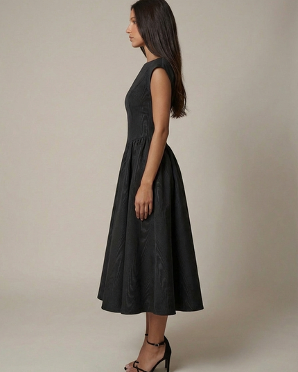 Back view of black sleeveless midi dress with open back and gathered midi skirt