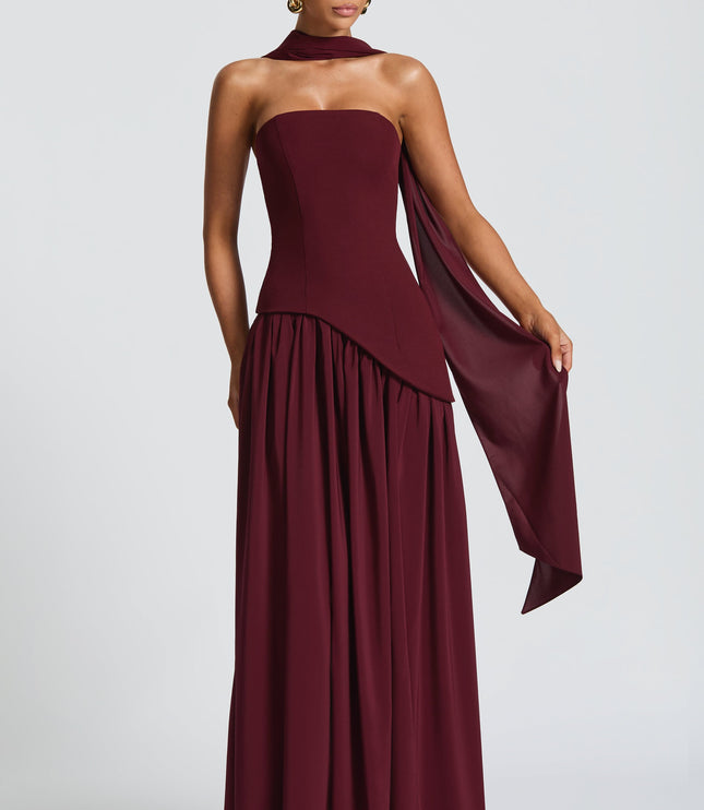 Burgundy strapless corset maxi dress with halter neckline and flowing skirt