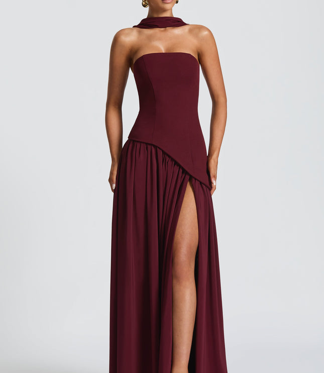 Burgundy strapless formal dress with asymmetrical pleated skirt and high slit
